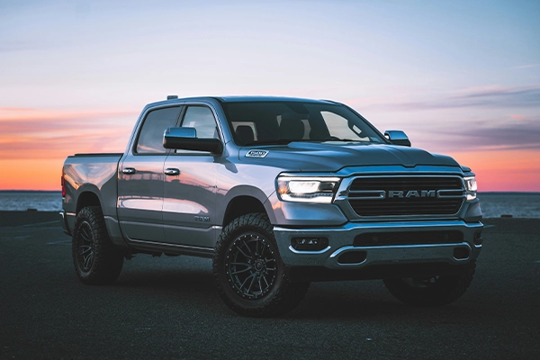 A truck parked in front of a sunset