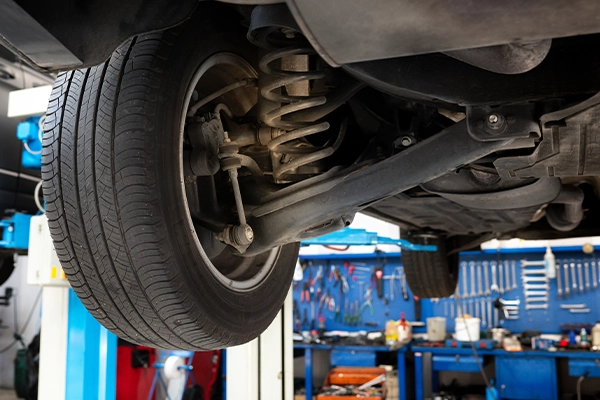 Underside of vehicle on lift showing springs in suspension system